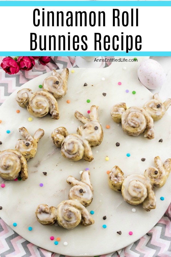 Cinnamon rolls in the shape of a bunny on a white plate on top of a chevron tablecloth. There are multicolored dots decorating the cloth