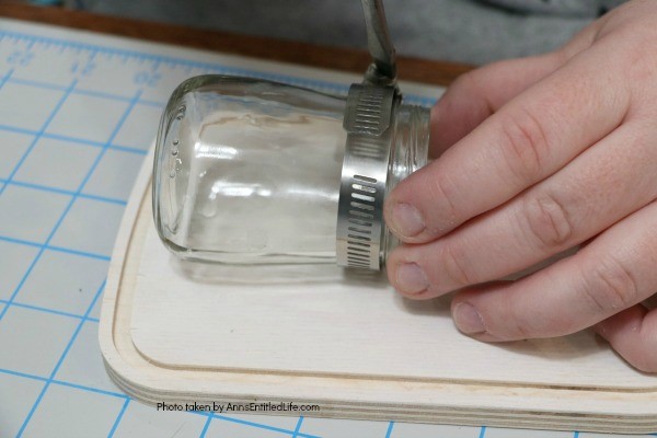 Farmhouse Décor: Jar Flower Holder. This adorable little jar flower holder is easy to make, rustic decor. Great indoors or outdoors decorating, this sweet little bud vase fills in that small section of open wall space perfectly. The step-by-step tutorial will show you how to make this simple DIY farmhouse décor jar flower holder inexpensively.