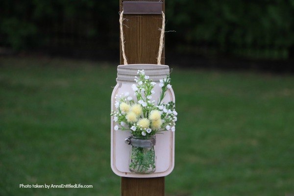 Farmhouse Décor: Jar Flower Holder. This adorable little jar flower holder is easy to make, rustic decor. Great indoors or outdoors decorating, this sweet little bud vase fills in that small section of open wall space perfectly. The step-by-step tutorial will show you how to make this simple DIY farmhouse décor jar flower holder inexpensively.