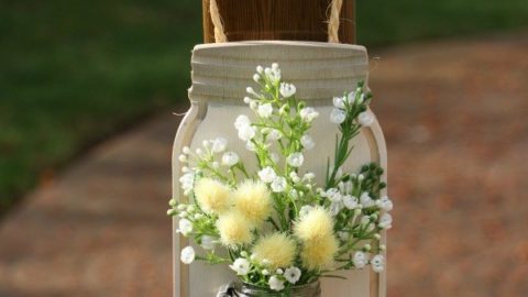 Farmhouse Décor: Jar Flower Holder. This adorable little jar flower holder is easy to make, rustic decor. Great indoors or outdoors decorating, this sweet little bud vase fills in that small section of open wall space perfectly. The step-by-step tutorial will show you how to make this simple DIY farmhouse décor jar flower holder inexpensively.