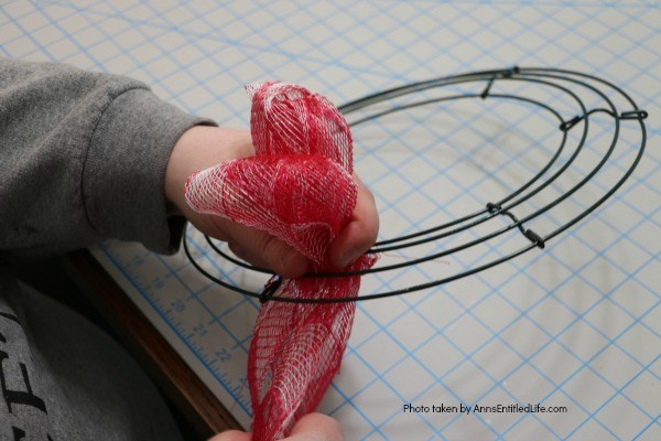 Patriotic Farmhouse Wreath DIY. This simple to make, rustic style American patriotic mesh farmhouse wreath is wonderful for outdoor or indoor display. Using only three materials and scissors, this easy to make wreath comes together in about 15 minutes. If you are looking for a patriotic holiday wreath, this little beauty is it!