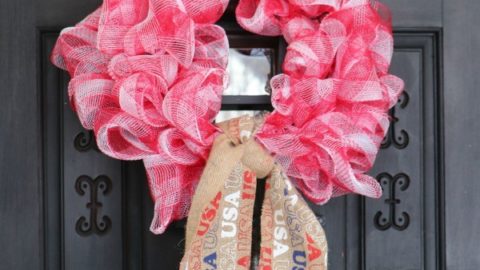 Patriotic Farmhouse Wreath DIY, This simple to make, rustic style American patriotic mesh farmhouse wreath is wonderful for outdoor or indoor display. Using only three materials and scissors, this easy to make wreath comes together in about 15 minutes. If you are looking for a patriotic holiday wreath, this little beauty is it!