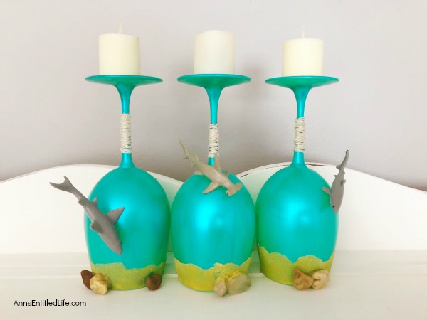 Beach Wineglass DIY Décor. Make your own beach themed wineglasses with these easy step-by-step tutorial instructions. This is a great summertime craft, makes a fabulous shark week decoration, or if you have beach themed décor in your home or on your lanai, patio or in your three-season room, this is a fun and funky craft project to add to it. These highly customizable beach wineglasses are simple to make and will look great on your mantel, side table or as part of a larger décor theme.