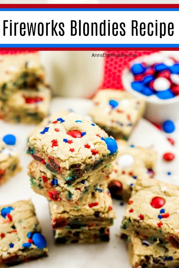 festive red, white, and blue blondies bars on a white plate, M&Ms upper right, milk glass on red polka dot napkin upper center