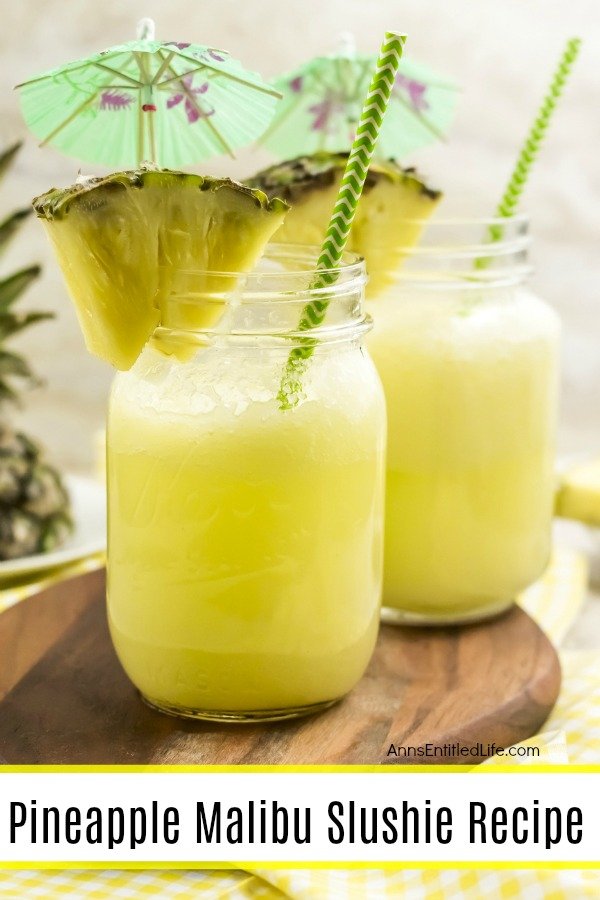 2 yellow pineapple cocktails on a brown wooden board, with fresh pineapple garnish and decorative drink umbrellas