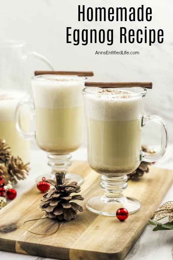 two glasses of homemade eggnog on butcher block, with pinecone and red bulbs scattered about