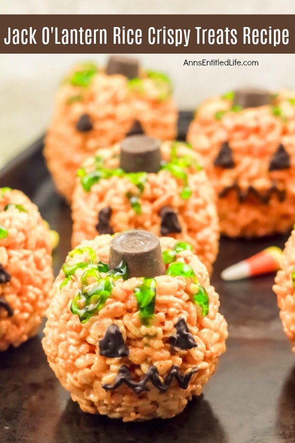 5 jack o'lantern halloween treats made with crispy rice cereal on a dark tray