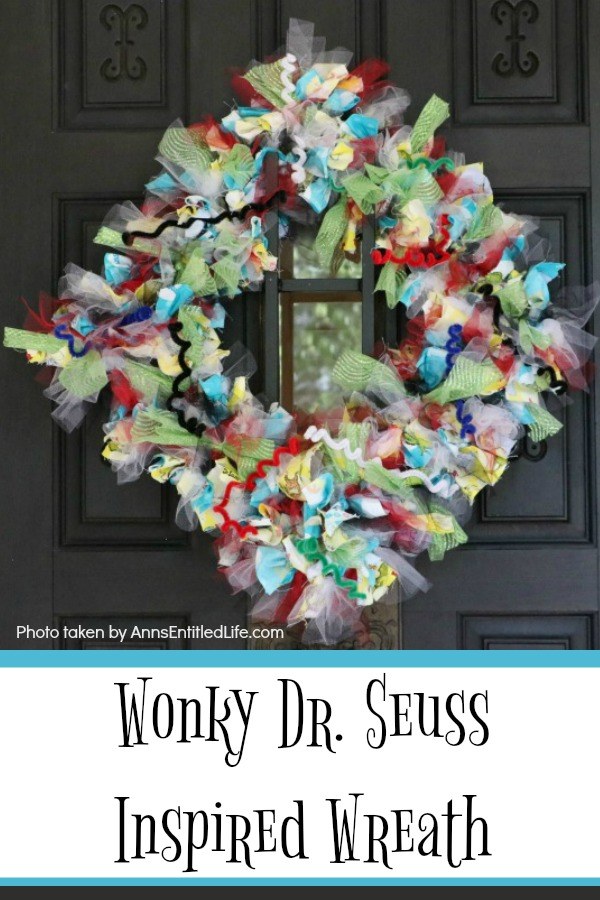 multicolored wreath with a Dr. Seuss theme hung diagonally on a dark-colored front door