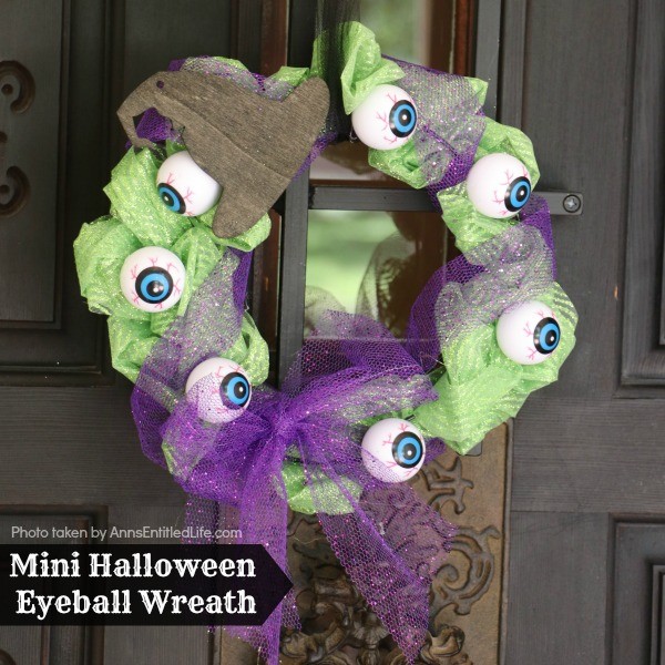 Mini Halloween Eyeball Wreath. This spooky little Halloween eyeball wreath is simple to make by following these step by step tutorial instructions. A fast Halloween decor craft, you can use these mini wreaths to decorate cabinets, desks, or as great Halloween party decor accessory.