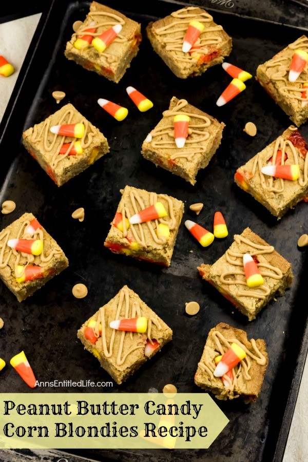peanut butter candy corn blondies on top of a black tray, dropped candy corn and peanut butter chips for garnish