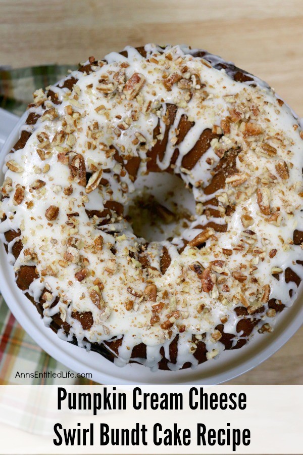 a Pumpkin Cream Cheese Swirl Bundt Cake sitting on a serving dish atop a butcherblock counter