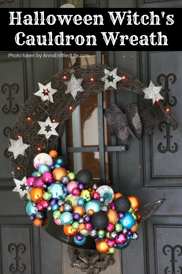 multicolored bulbs formed to imitate bubbles flowing from the cauldron attached to a half-moon black prelit wreath, hanging on a black door