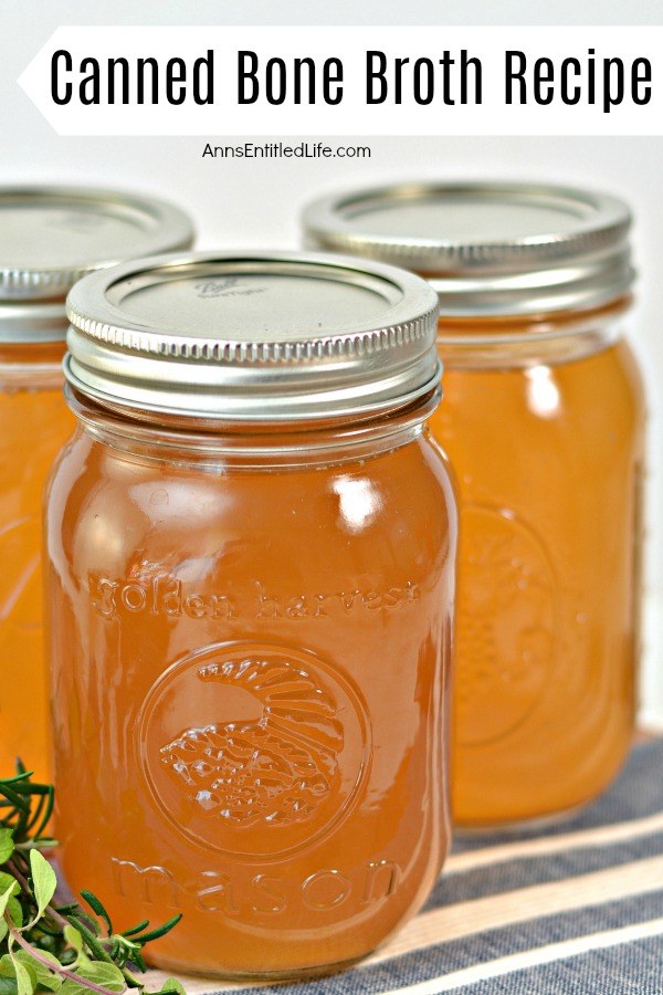 Three jars of canned bone broth on a blue and white striped towel