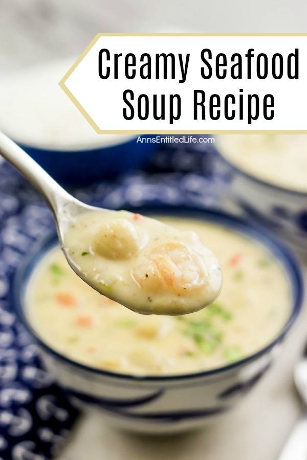 a spoon full of creamy seafood soup being lifted from the blue and white bowl filled with the soup, a blue anchor patterned napkin in the left background, a bowl of rice in the center background, another bowl of soup in the right background