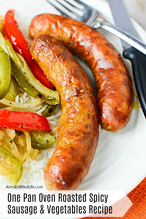 Two cooked sausages next to cooked peppers and onions on a bed of rice atop a white plate, serving utensils to the right