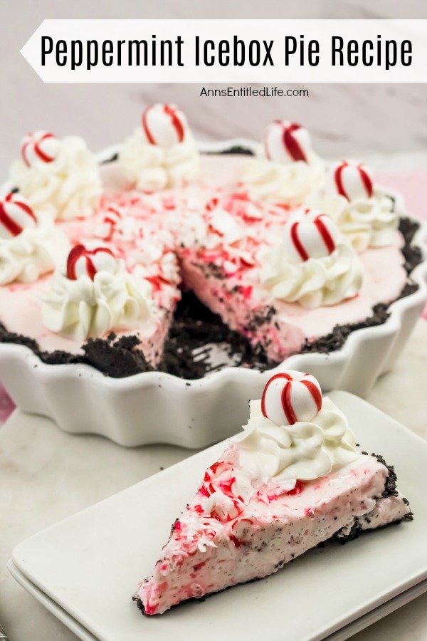A peppermint icebox cake in a round fluted white plate decorated with peppermint candies and whipped cream sits in the background, one piece is removed. That piece is on a white plate in the foreground.