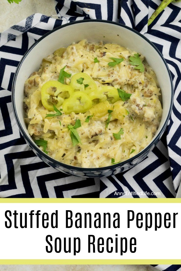 A black bowl with a white interior is filled with banana pepper soup, decorated with sliced banana peppers. This is set upon a black and white chevron napkin.