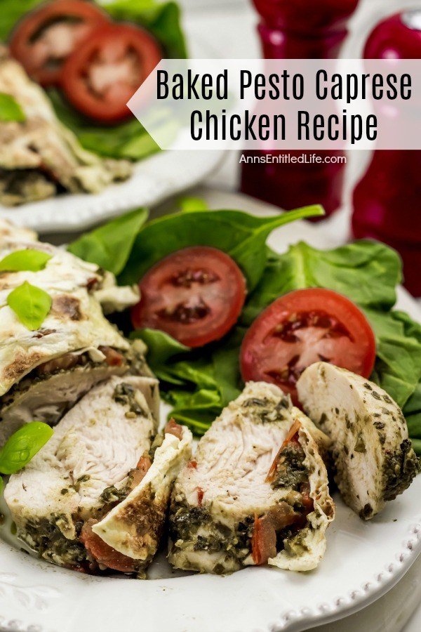 Close-up of a cut up piece of chicken with mozzarella on top of it, tomato and lettuce side dish on a white plate. There is a second, identical plated chicken in the upper left.