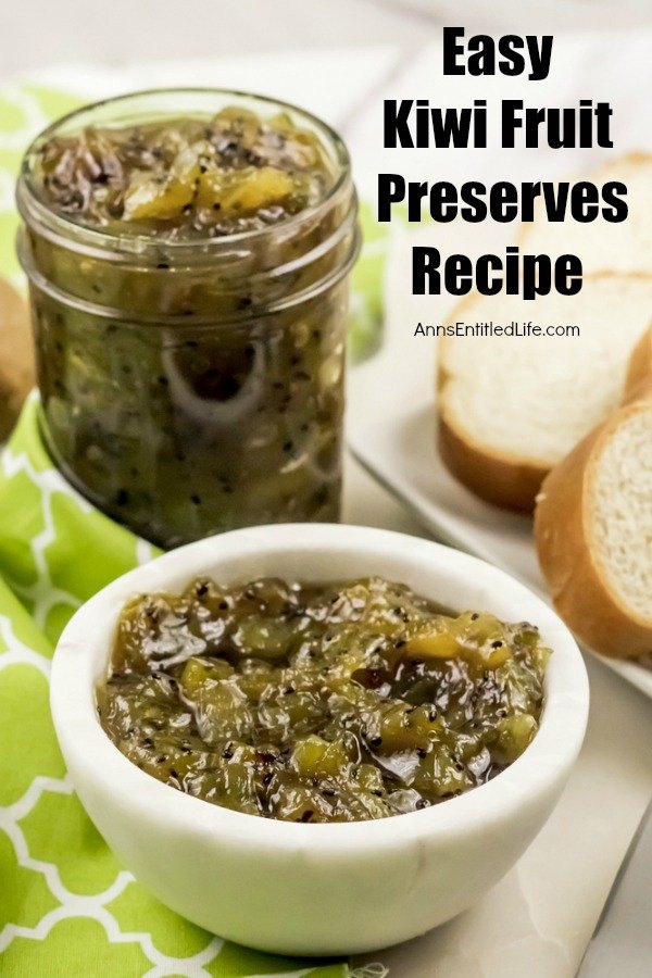 View of kiwi fruit preserves in a white bowl a Mason jar filled with the same recipe to the back left, n a green checked napkin. There is a side of bread to the right.