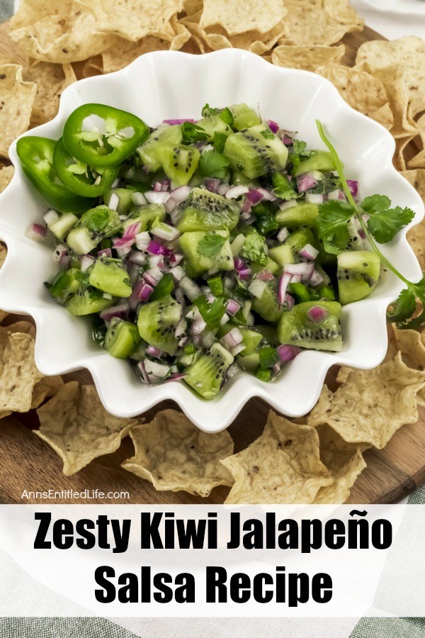 white bowl filled with kiwi fruit jalapeño salsa surrounded by tortilla chips