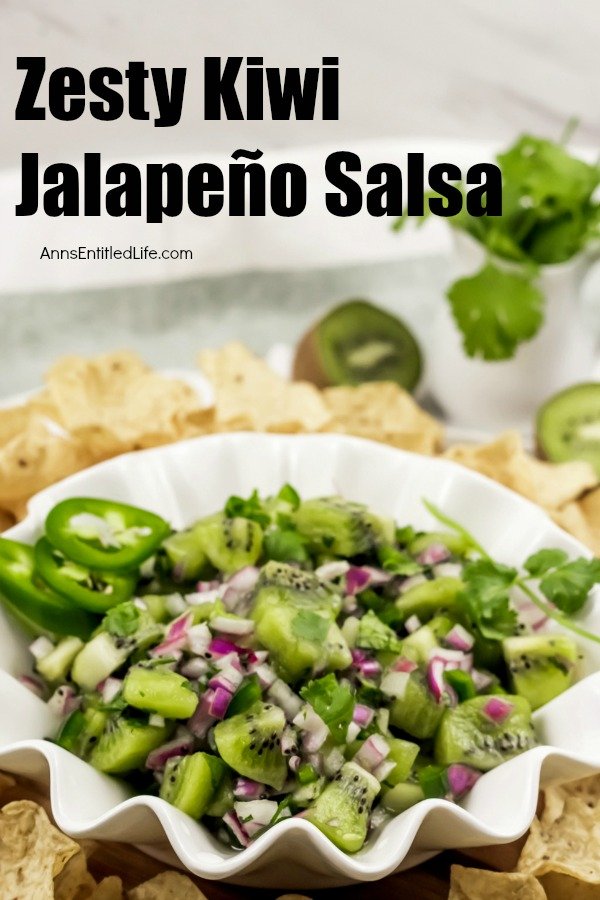 white bowl filled with kiwi fruit jalapeño salsa surrounded by tortilla chips, a dish of cilantro in the right background