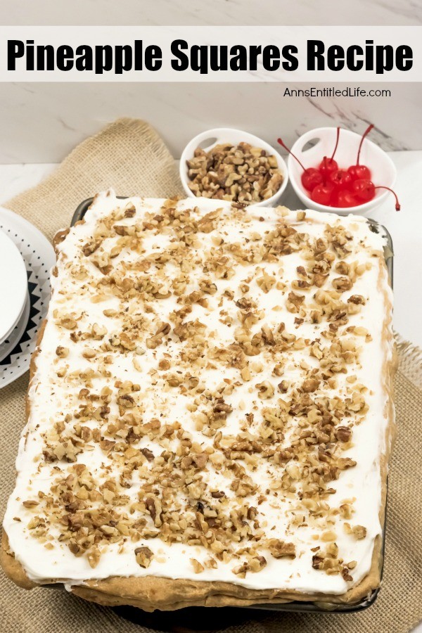 A pan of frosted pineapple squares topped with crushed walnuts, a small bowl of cherries n the upper right, a bowl of chopped walnuts to its left.