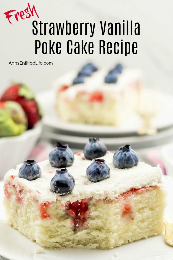 A piece of strawberry vanilla poke cake on a white plate is in the center of the image. Another cut piece is in the upper right, a bowl of strawberries is blurred in the upper left.