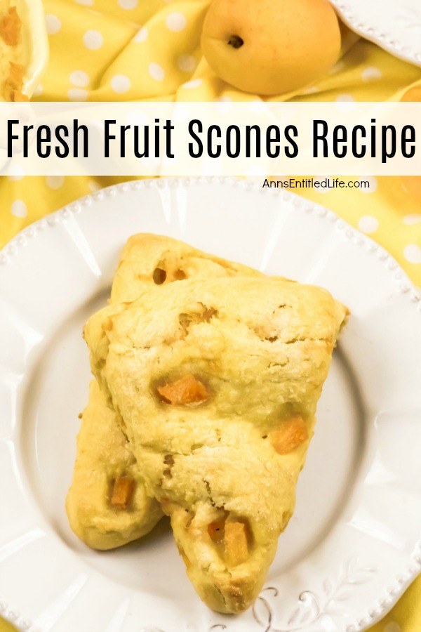 Two stacked apricot scones ona white plate, the white plate is on top of a yellow polka dot napkin. A fresh apricot is in the upper right.