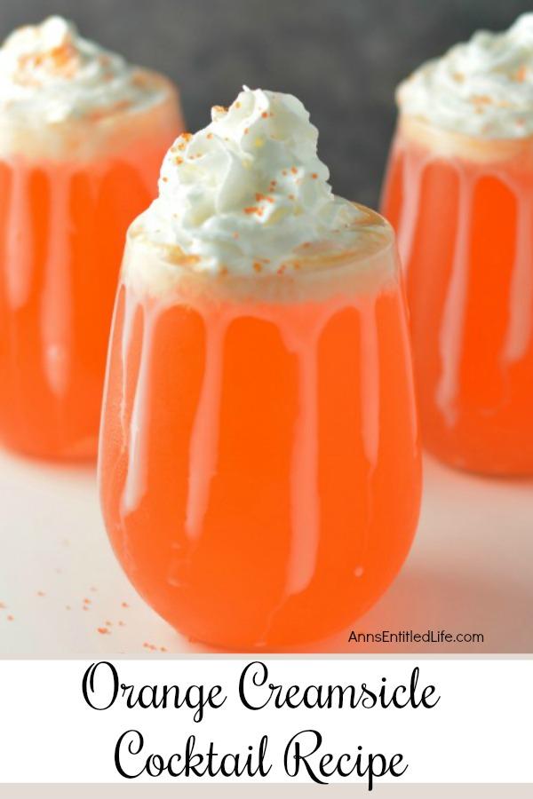 Three glasses set up in a V filled with orange creamsicle cocktail. There is sweetened condensed milk dripping down each glass, and the cocktails are topped with whipped cream.