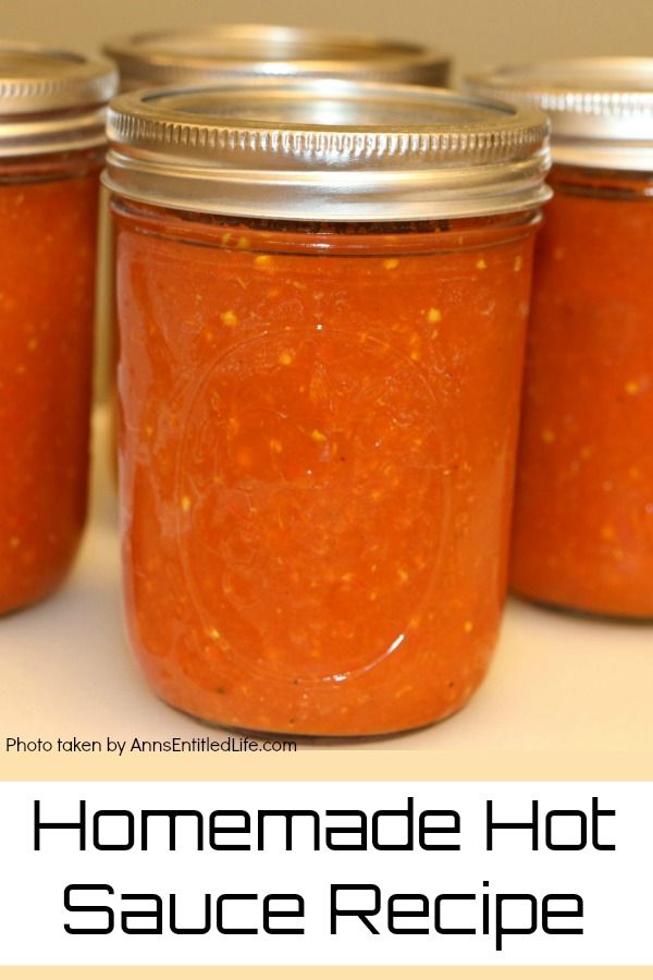 4 pint jars of homemade hot sauce arranged in a diamond shape on a pale tan surface