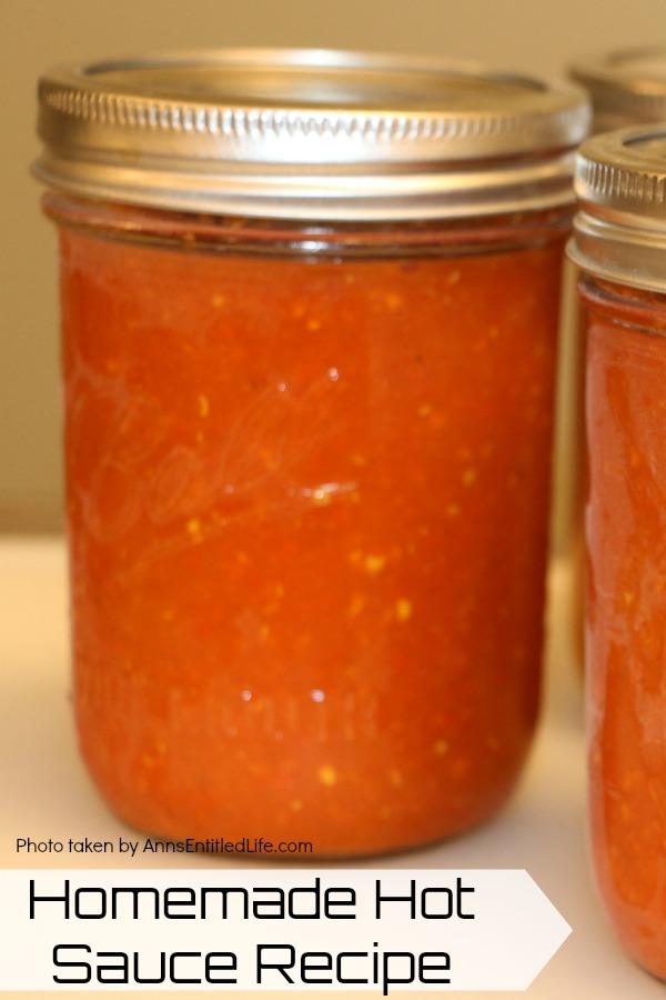 a pint jar of homemade hot sauce front and center, two other jars to the right are partially shown, all on a pale tan surface