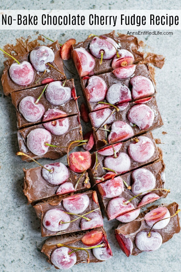 An overhead photo of a whole fresh cherry chocolate fudge cut into pieces, on top of a blue background.