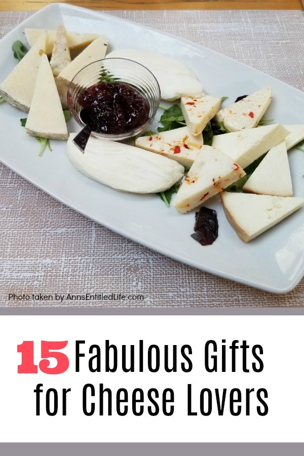 A white tray filled with various cheeses and a clear bowl of jam