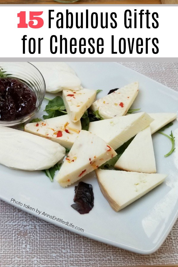 A white tray filled with various cheeses and a clear bowl of jam