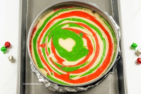 Christmas Cheesecake Recipe. Impress your friends and family with this gorgeous Christmas Cheesecake. You will delight taste buds when you serve this dressed-up classic sour cream cheesecake recipe for the holidays. The wonderful swirls of color add a dash of magical wonder to match the holiday season and form a perfect holiday dessert.