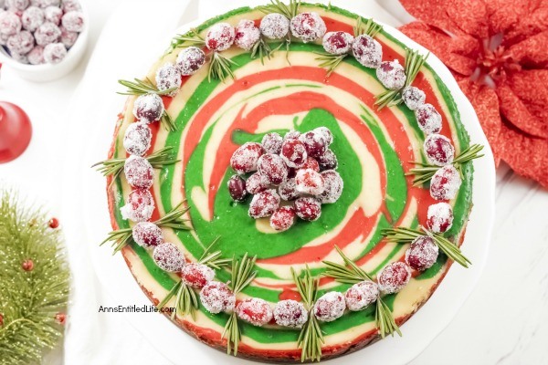 Christmas Cheesecake Recipe. Impress your friends and family with this gorgeous Christmas Cheesecake. You will delight your taste buds when you serve this dressed-up classic sour cream cheesecake recipe for the holidays. The beautiful swirls of color add a dash of magical wonder to match the holiday season and form a perfect holiday dessert.