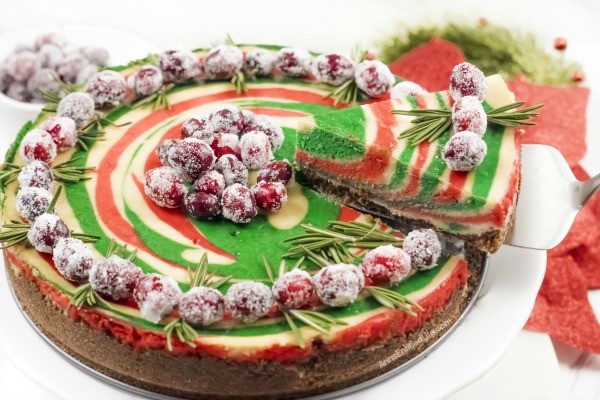 Christmas Cheesecake Recipe. Impress your friends and family with this gorgeous Christmas Cheesecake. You will delight your taste buds when you serve this dressed-up classic sour cream cheesecake recipe for the holidays. The beautiful swirls of color add a dash of magical wonder to match the holiday season and form a perfect holiday dessert.