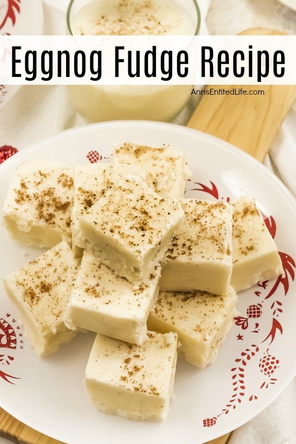 A white and red plate filled with cut pieces of eggnog fudge. There is a glass of eggnog directly above. They are sitting on a cutting board.