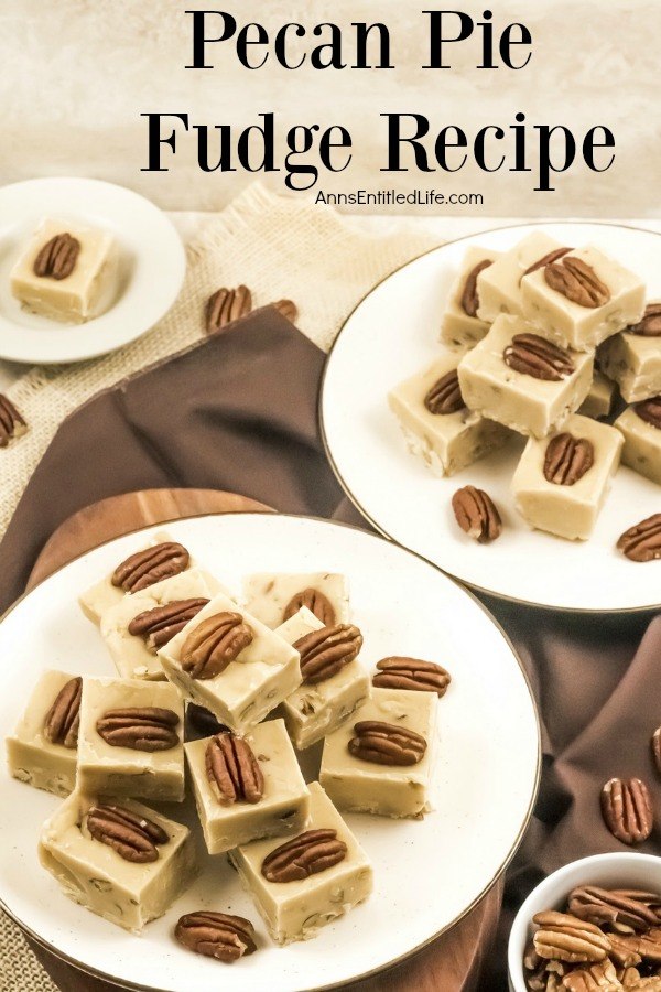A white plate with gold trim is filled with stacked pieces of pecan pie fudge. In the background is a second plate in the upper right, and to the back left is a plate with a single piece of pumpkin pie fudge. A small bowl of pecan halves sits in the front right.