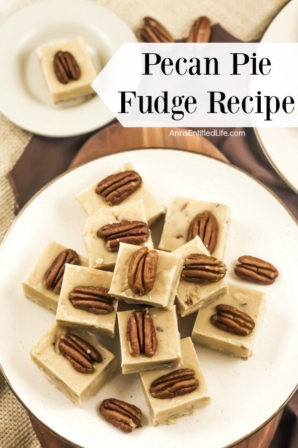 An overhead view of a white plate with gold trim that is filled with stacked pieces of pecan pie fudge. In the background is a second plate of fudge in the upper right, a few pecan halves sit in the center back, and to the back left is a plate with a single piece of pumpkin pie fudge.