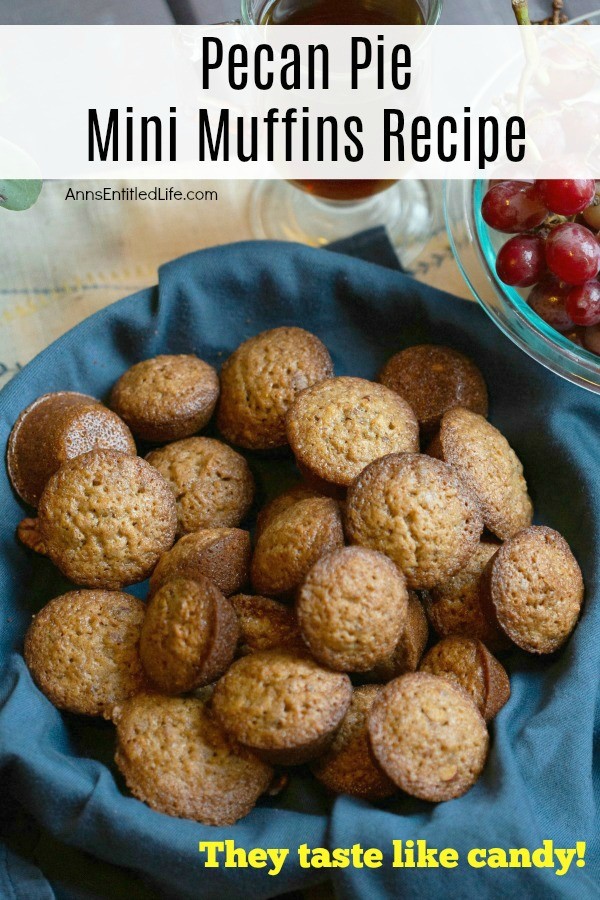 An overhead view of a basket with a blue napkin lining it, of mini pecan pie muffins. In the far upper right background is a bowl of grapes, right above the bowl is a cup of coffee.