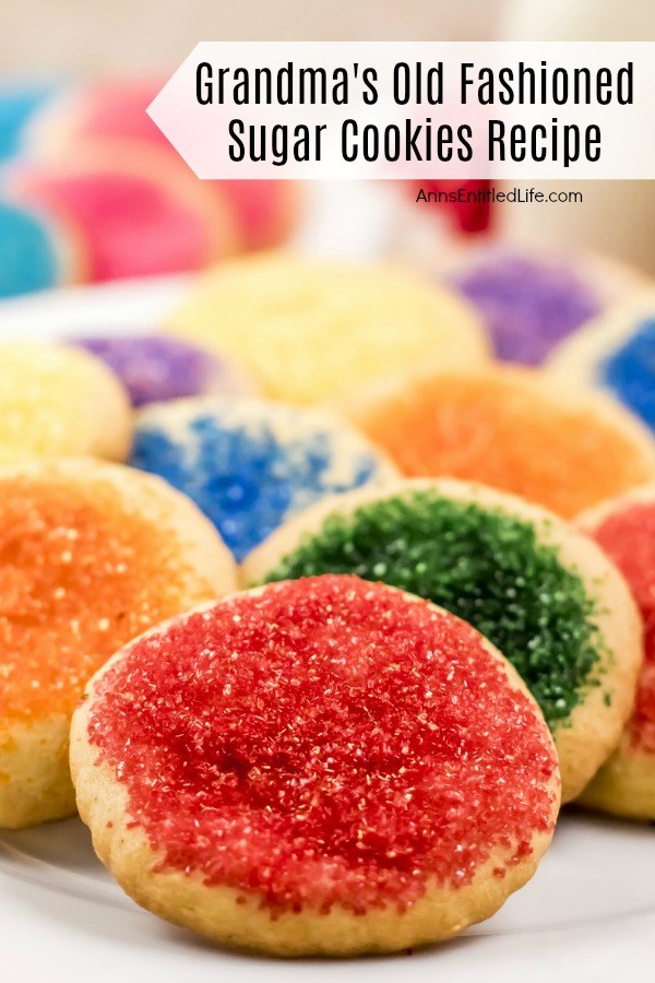 A close-up of a white plate filled with homemade sugar cookies with various sugar tops.