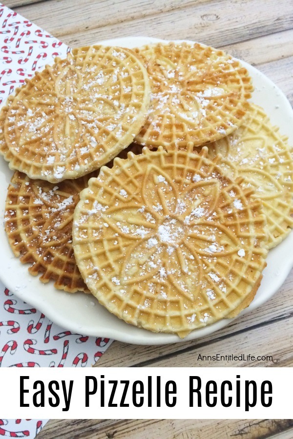 A white plate filled with pizzelles which are covered in powder sugar