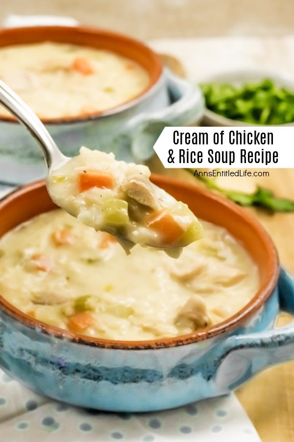  an up-close image of a spoonful of cream of chicken and rice soup being lifted from a blue soup bowl. There is a second bowl in the upper left. The bowls are set on a cutting board