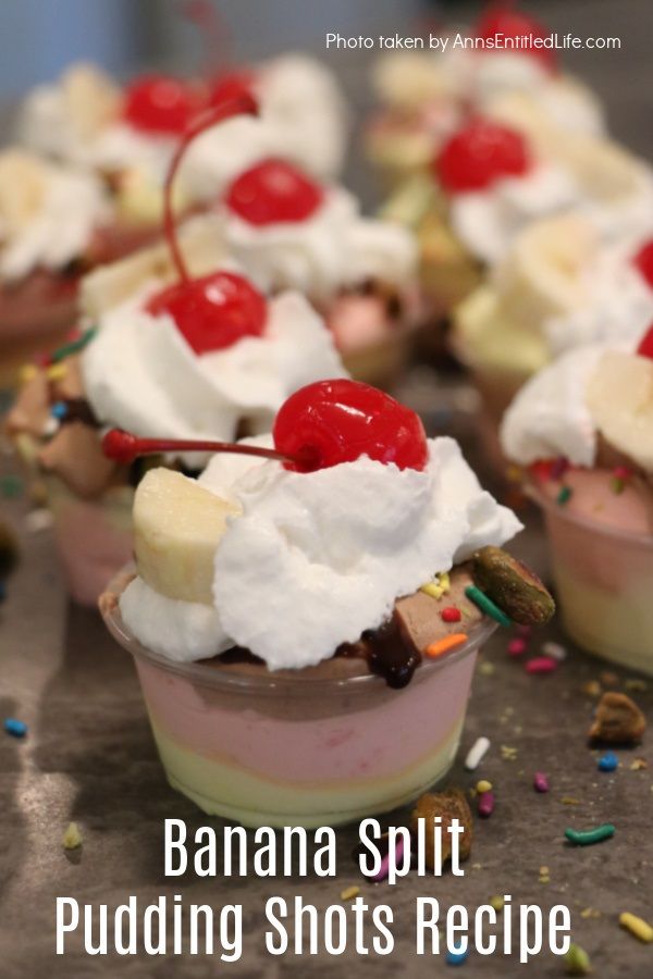 A banana split pudding shot in a souffle container, there are other banana split pudding shots in the background