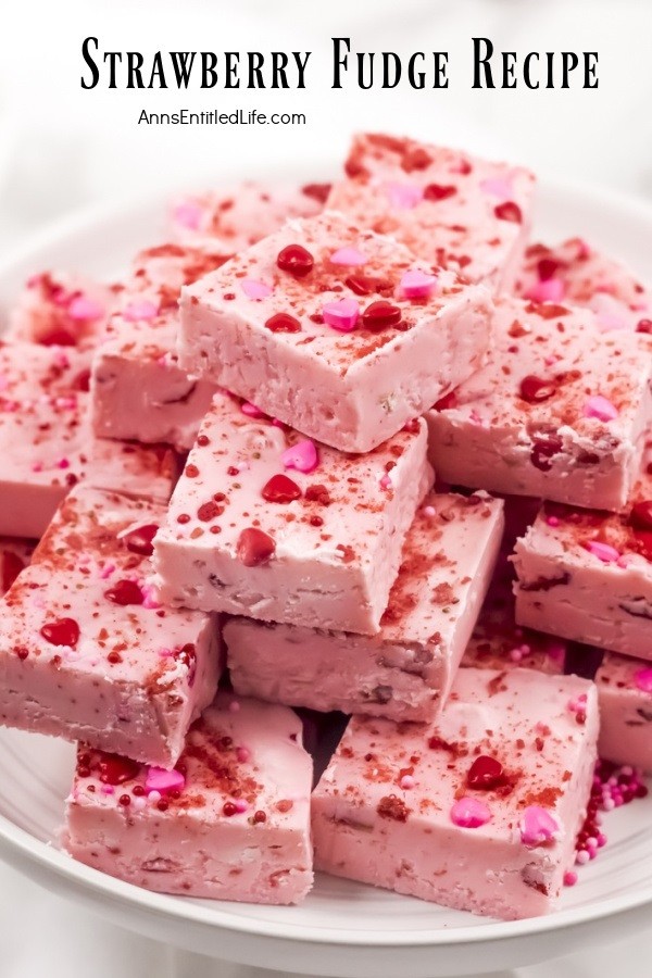 Strawberry fudge squares stacked in a pyramid shape on a white plate
