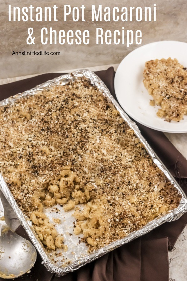 Pan of macaroni and cheese with a serving remove. That serving is in the upper right on a white plate.