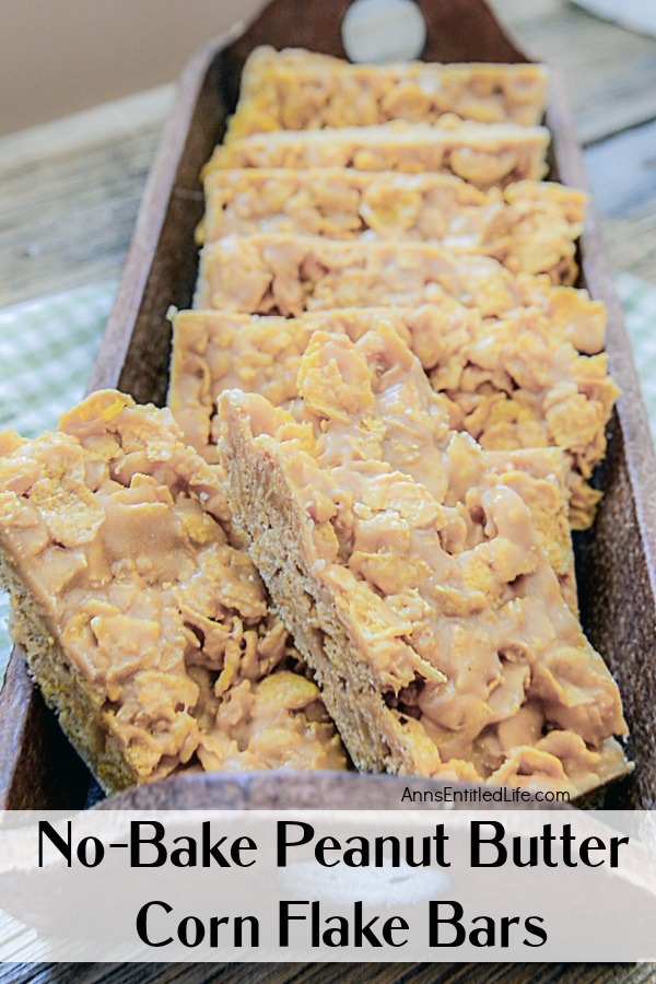 peanut butter bars in a wooden tray on a blue and white checkered kitchen towel