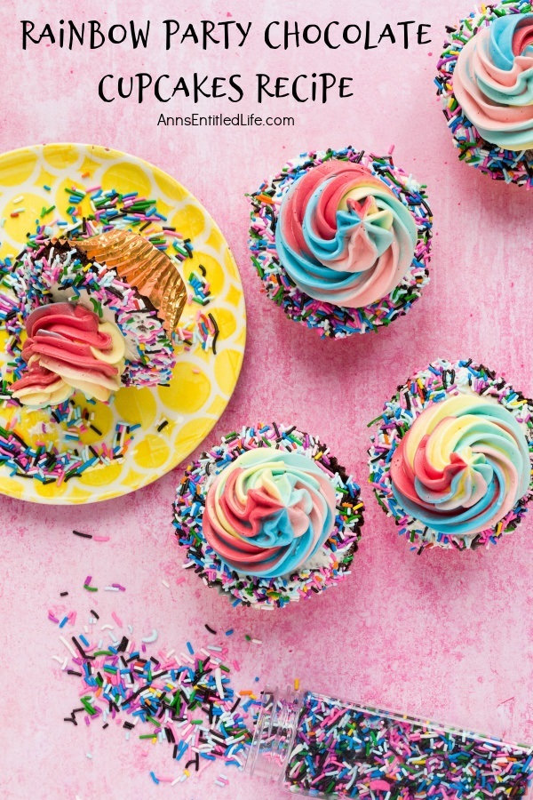 4 rainbow party chocolate cupcakes on the right hand side, a yellow plate is to the left with one tipped cupcake, a container of colored sprinkles is tipped over down below. All is set on a pink background.