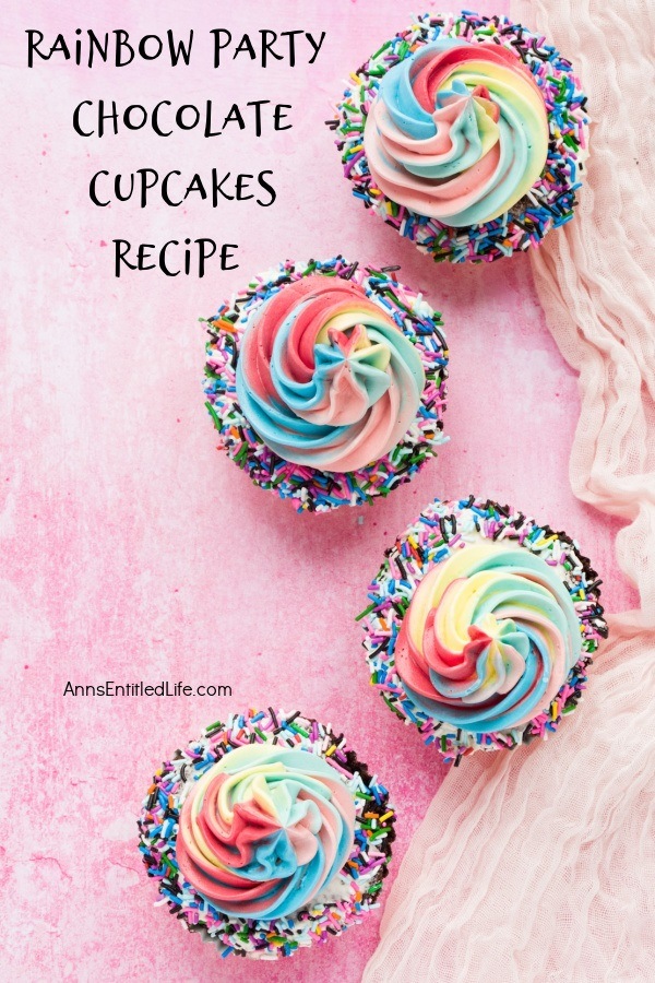 An overhead view of 4 rainbow party chocolate cupcakes on the right hand side, set on a pink background.